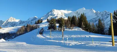 a ski slope with snow covered mountains in the background at Charmant appartement T3 avec magnifique vue in Saint-Gervais-les-Bains