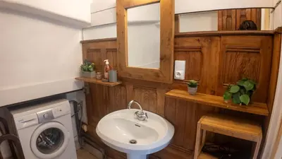 a bathroom with a sink and a washing machine at Chalet la Pagode, vue Mont-Blanc et jardin privé in Chamonix-Mont-Blanc