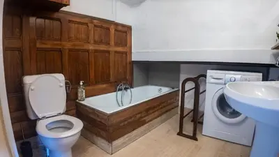 a bathroom with a tub and a toilet and a sink at Chalet la Pagode, vue Mont-Blanc et jardin privé in Chamonix-Mont-Blanc
