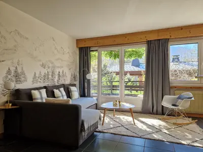a living room with a couch and a table at Les Tussilages - Terrasse vue Mont-Blanc in Chamonix-Mont-Blanc