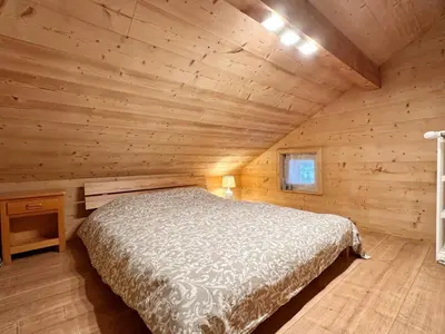 a bedroom in a log cabin with a bed at Appartement T4 au calme avec jardin et wifi, proche du centre et ski-bus - FR-1-624-150 in Samoëns