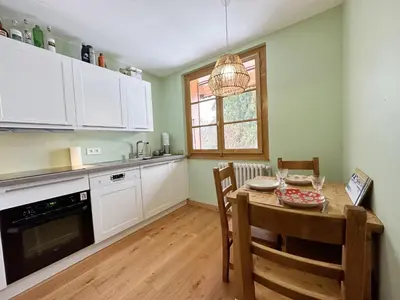 a kitchen with a table and chairs and a dining room at Appartement T4 au calme avec jardin et wifi, proche du centre et ski-bus - FR-1-624-150 in Samoëns