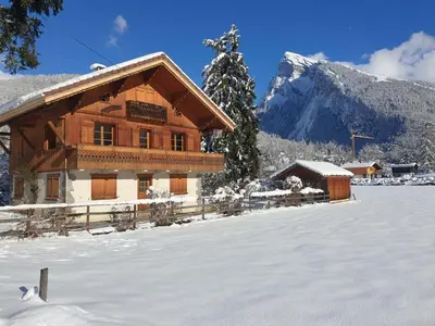 a log cabin in the snow with a mountain at Appartement T4 au calme avec jardin et wifi, proche du centre et ski-bus - FR-1-624-150 in Samoëns