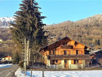 a wooden house in the snow with a tree at Appartement T4 au calme avec jardin et wifi, proche du centre et ski-bus - FR-1-624-150 in Samoëns