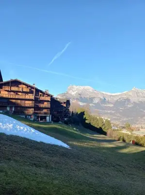 a resort with a building and mountains in the background at Hike, Bike, Ski, open the door and Go! in Saint-Gervais-les-Bains