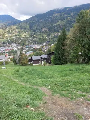 a building on a hill with mountains in the background at Hike, Bike, Ski, open the door and Go! in Saint-Gervais-les-Bains