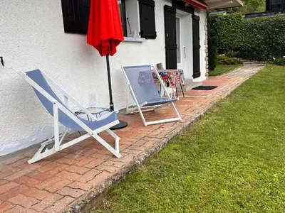 two chairs and an umbrella next to a house at Appartement cosy avec vue exceptionnelle in Saint-Gervais-les-Bains