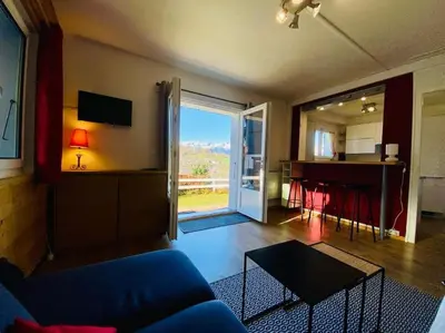 a living room with a blue couch and a table at Appartement cosy avec vue exceptionnelle in Saint-Gervais-les-Bains
