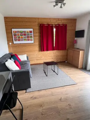 a living room with a couch and red curtains at Appartement cosy avec vue exceptionnelle in Saint-Gervais-les-Bains