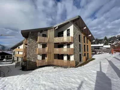 a apartment building in the snow with snow at Appartement de standing 3P au pied des pistes, terrase privée, parking, à 350m du centre-village - FR-1-572-294 in Arâches-la-Frasse