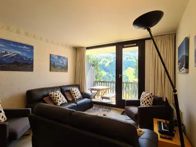 a living room with couches and a view of a mountain at Appartement spacieux au pied des pistes avec balcon et WIFI - FR-1-425-212 in Arâches-la-Frasse