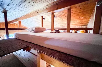 a large bed in a room with wooden walls at Snowflake cottage with garden in Chamonix-Mont-Blanc