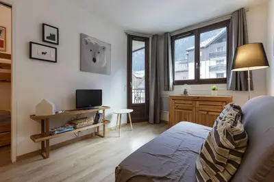 a bedroom with a bed and a desk with a tv at Les Marmottes En Chaussettes - Happy Rentals in Chamonix-Mont-Blanc