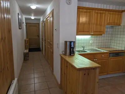a kitchen with wooden cabinets and a coffee maker on a counter at Appartement Cosy avec Terrasse et Garage in Les Houches