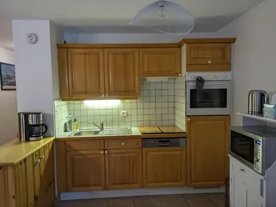 a kitchen with wooden cabinets and a sink at Appartement Cosy avec Terrasse et Garage in Les Houches