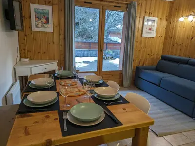 a dining room table with plates and wine glasses at Appartement Cosy avec Terrasse et Garage in Les Houches