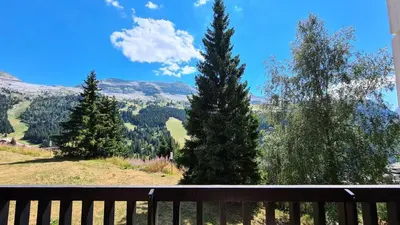 a view from a balcony of trees and mountains at Résidence Belier - Appartement confortable et spacieux · Au pied des pistes · WIFI gratuit et illimité MAE-8211 in Magland