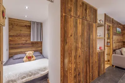 a teddy bear sitting on a bed in a bedroom at Villa Princesse - Centre-ville - Renove in Chamonix-Mont-Blanc