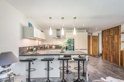 a kitchen with a island with bar stools at Villa Princesse - Centre-ville - Renove in Chamonix-Mont-Blanc