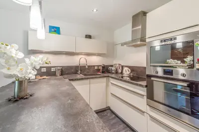 a kitchen with white cabinets and stainless steel appliances at Villa Princesse - Centre-ville - Renove in Chamonix-Mont-Blanc