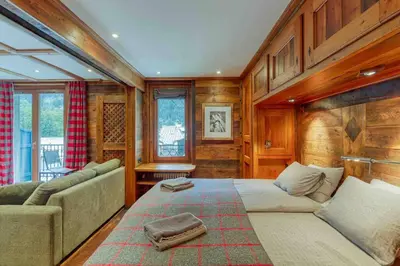 a bedroom with a large bed and a couch at Chamonix centre, « Lucille »,balcon, vue imprenable et parking in Chamonix-Mont-Blanc