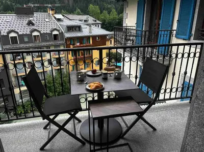 a table with a plate of food on a balcony at Chamonix centre, « Lucille »,balcon, vue imprenable et parking in Chamonix-Mont-Blanc