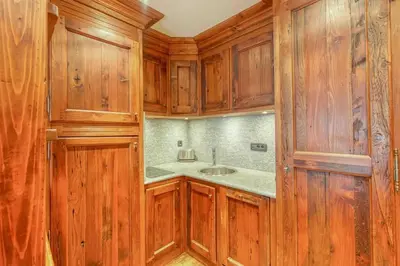 a kitchen with wooden cabinets and a sink at Chamonix centre, « Lucille »,balcon, vue imprenable et parking in Chamonix-Mont-Blanc