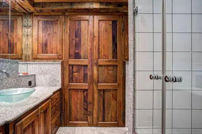 a bathroom with a wooden door and a sink at Chamonix centre, « Lucille »,balcon, vue imprenable et parking in Chamonix-Mont-Blanc