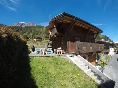 a log cabin with a grassy yard in front of it at Chalet Indépendant 