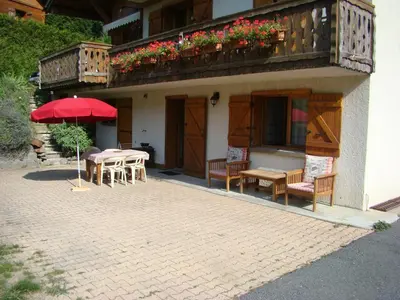 a patio with tables and chairs and an umbrella at Studio 