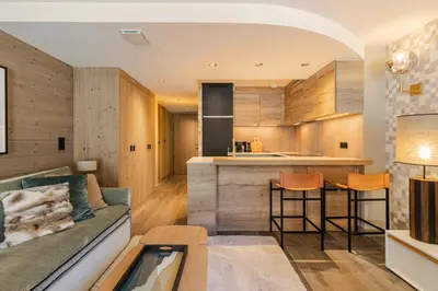 a kitchen and living room with a couch and a bar at Rochebrune - Superbe studio au départ des pistes in Megève