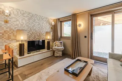 a living room with a tv and a couch at Rochebrune - Superbe studio au départ des pistes in Megève
