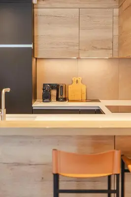 a kitchen with a counter with a chair in front of a counter sidx sidx sidx at Rochebrune - Superbe studio au départ des pistes in Megève