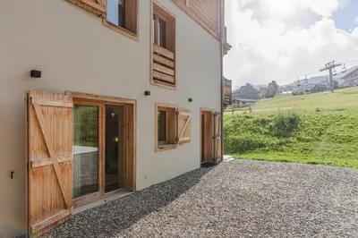 a house with wooden doors on the side of it at Rochebrune - Superbe studio au départ des pistes in Megève