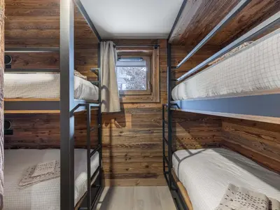two bunk beds in a cabin with wooden walls at Chalet avec spa partagé, 5 chambres, piscine, parkings à Megève - FR-1-569-187 in Megève