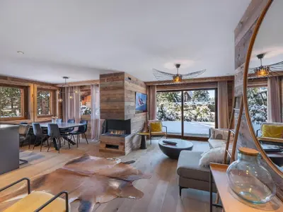 a living room with a fireplace and a dining room at Appartement neuf avec espace bien-être, sauna et hammam - FR-1-569-188 in Megève
