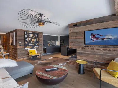 a living room with a large wooden wall at Appartement neuf avec espace bien-être, sauna et hammam - FR-1-569-188 in Megève