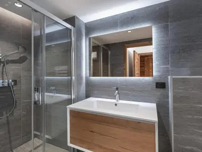 a bathroom with a sink and a shower and a mirror at Appartement neuf avec espace bien-être, sauna et hammam - FR-1-569-188 in Megève