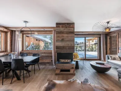 a living room with a table and a fireplace at Appartement neuf avec espace bien-être, sauna et hammam - FR-1-569-188 in Megève