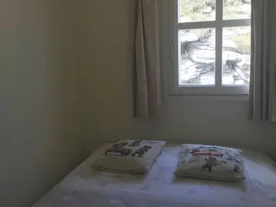 a bed with two pillows on it in a room with a window at Appartement confortable 2 chambres, balcon sud, 6 pers. - FR-1-425-213 in Arâches-la-Frasse