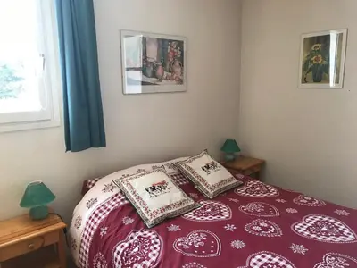 a bedroom with a red and white bed with two pillows at Appartement confortable 2 chambres, balcon sud, 6 pers. - FR-1-425-213 in Arâches-la-Frasse