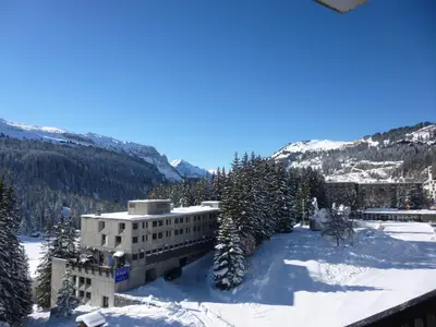 a building in the snow with trees and mountains at Appartement lumineux, pied des pistes - 6 pers. - FR-1-425-222 in Arâches-la-Frasse