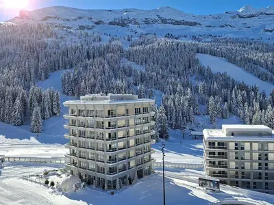 a building in the snow next to a mountain at Studio lumineux balcon ski aux pieds - 4 pers. - FR-1-425-223 in Arâches-la-Frasse
