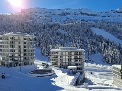 a large building with people in the snow in front of it at Appartement spacieux, balcon - 8 pers. - FR-1-425-218 in Arâches-la-Frasse