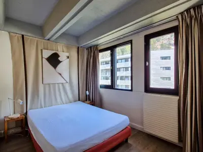 a bedroom with a white bed and two windows at Appartement spacieux, balcon, skis aux pieds - 8 pers. - FR-1-425-216 in Arâches-la-Frasse