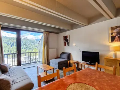 a living room with a couch and a large window at Appartement spacieux, balcon, skis aux pieds - 8 pers. - FR-1-425-216 in Arâches-la-Frasse