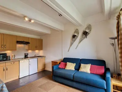 a living room with a blue couch in a kitchen at Studio confortable au pied des pistes - 4 pers. - FR-1-425-224 in Arâches-la-Frasse