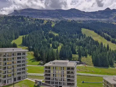 a large building with people in the snow in front of it at Studio confortable au pied des pistes - 4 pers. - FR-1-425-224 in Arâches-la-Frasse