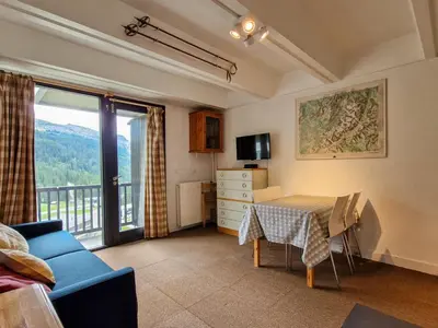 a living room with a table and a blue couch at Studio confortable au pied des pistes - 4 pers. - FR-1-425-224 in Arâches-la-Frasse