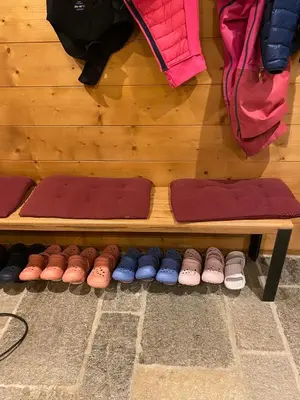 a row of different colored shoes on a wooden bench at Joyeux Flocon - Spacieux chalet in Les Contamines-Montjoie